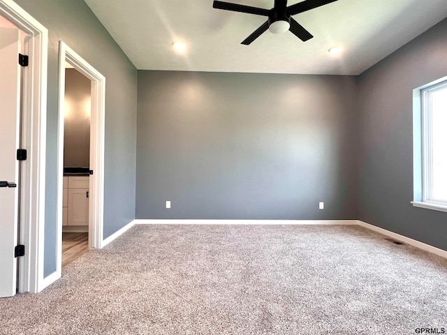 carpeted spare room with ceiling fan