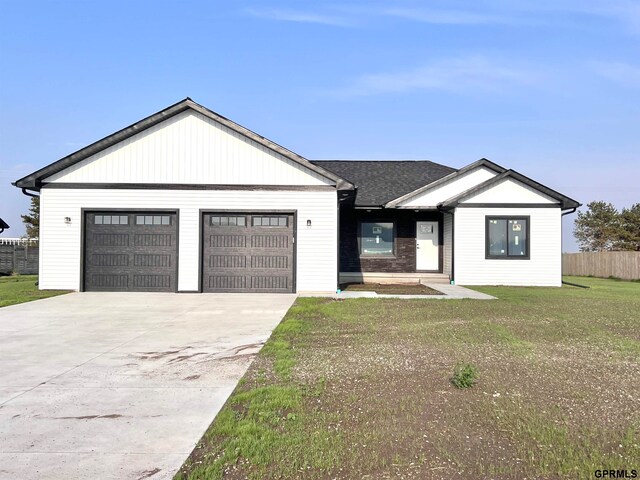 view of front of home with a front yard and a garage