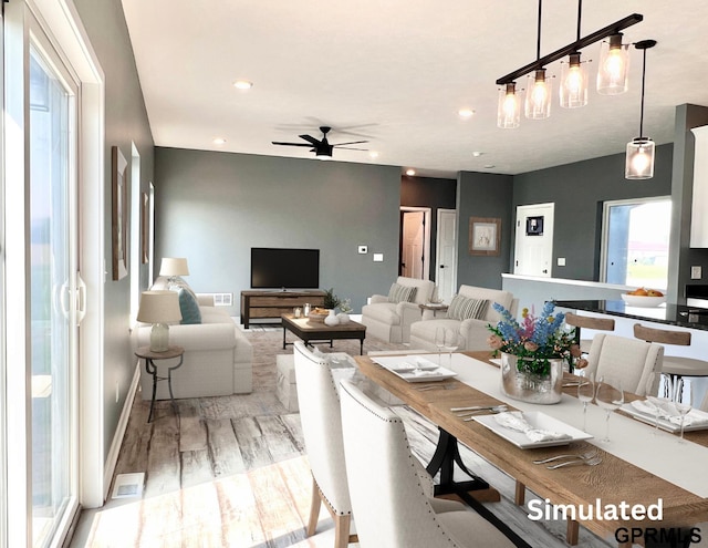 dining area with ceiling fan and light hardwood / wood-style floors