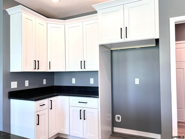 kitchen with dark hardwood / wood-style floors and white cabinetry