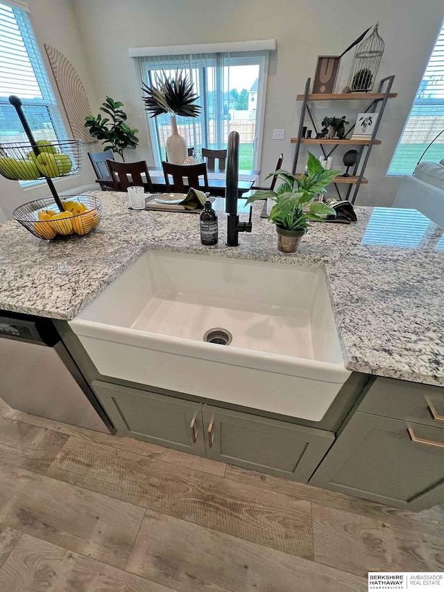 details featuring gray cabinets, light stone counters, and sink