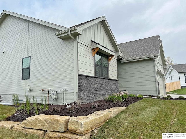 view of side of property featuring a garage and a lawn