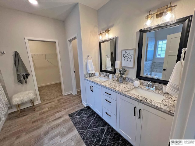 bathroom featuring vanity, hardwood / wood-style flooring, and a bathing tub