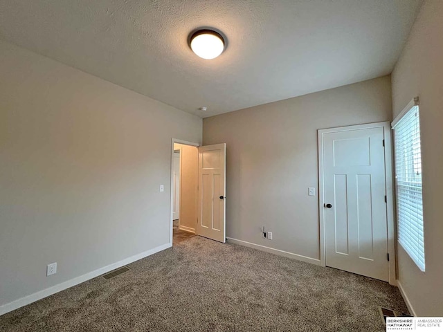 unfurnished bedroom featuring carpet floors and a textured ceiling