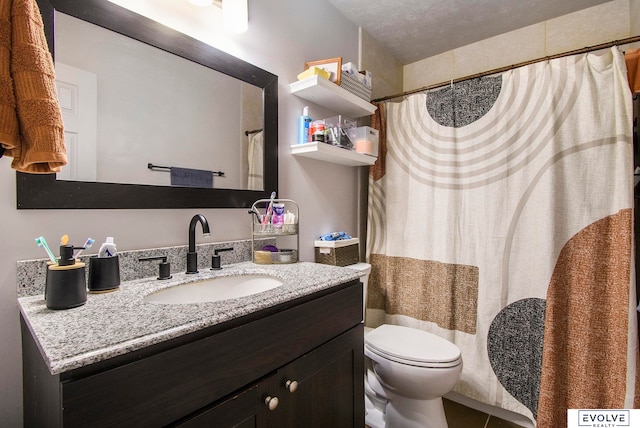 bathroom featuring a textured ceiling, vanity, and toilet