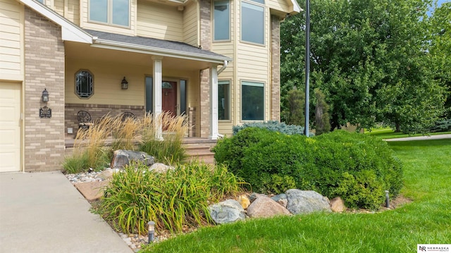 view of exterior entry with a lawn