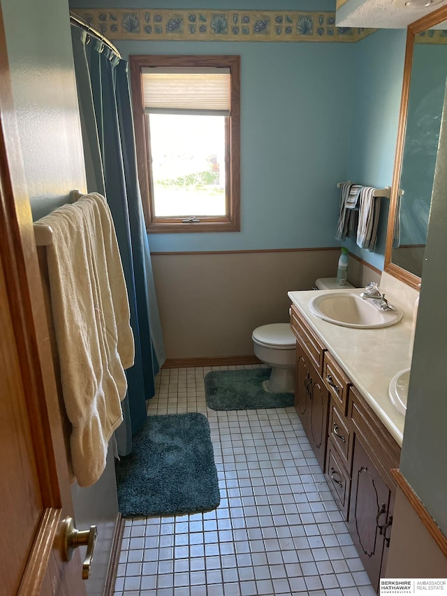 bathroom with tile patterned floors, vanity, and toilet