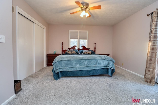 carpeted bedroom featuring ceiling fan, a closet, and a textured ceiling