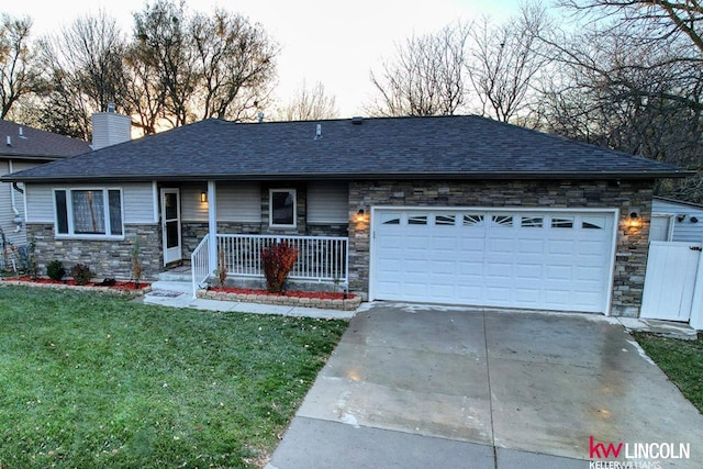 view of front of house with covered porch, a garage, and a front yard