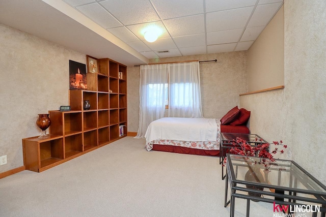 carpeted bedroom with a drop ceiling