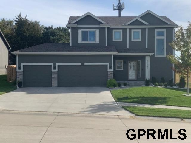 craftsman inspired home featuring a front yard and a garage