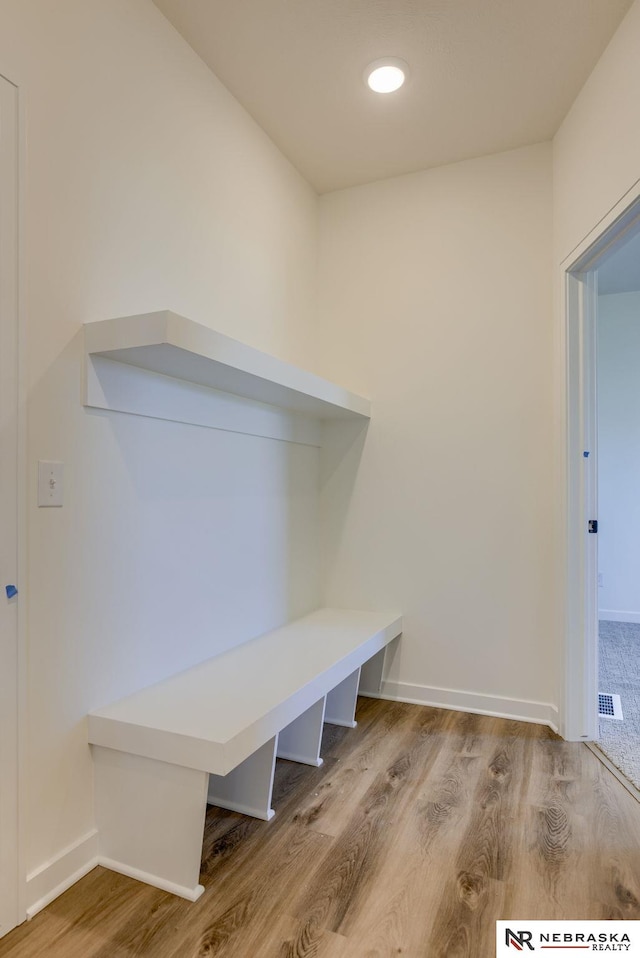 mudroom with visible vents, baseboards, and wood finished floors