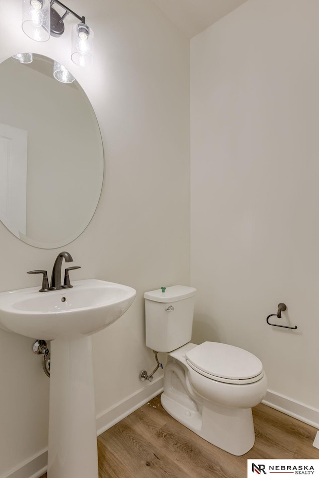 bathroom with sink, hardwood / wood-style floors, and toilet