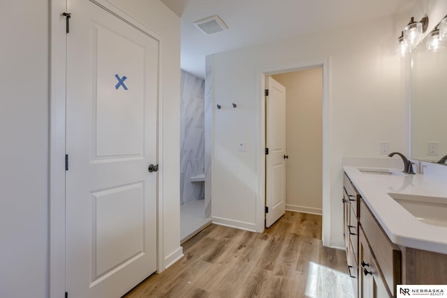 bathroom with vanity, hardwood / wood-style floors, and walk in shower