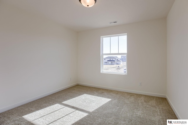 spare room with visible vents, baseboards, and light carpet