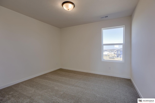 empty room featuring visible vents, baseboards, and carpet