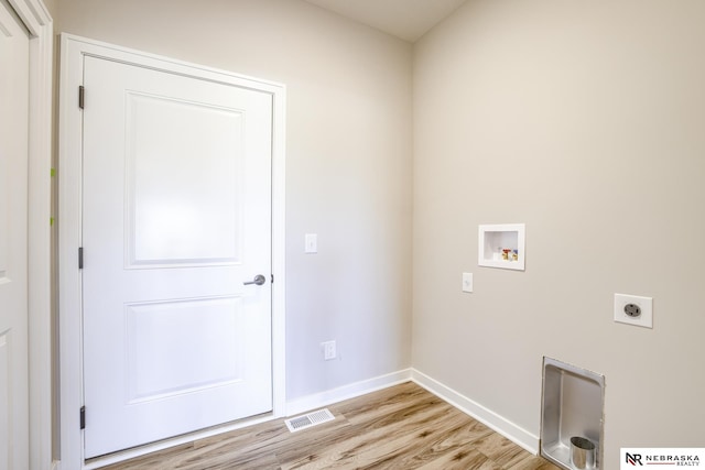 clothes washing area featuring hookup for a washing machine, light hardwood / wood-style flooring, and hookup for an electric dryer