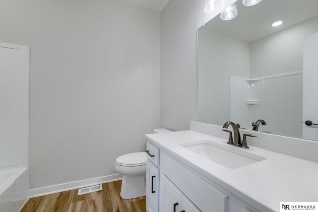 full bathroom featuring hardwood / wood-style flooring, vanity, shower / bath combination, and toilet