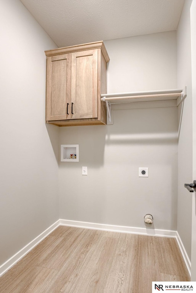 clothes washing area featuring cabinet space, baseboards, hookup for an electric dryer, light wood-style floors, and washer hookup