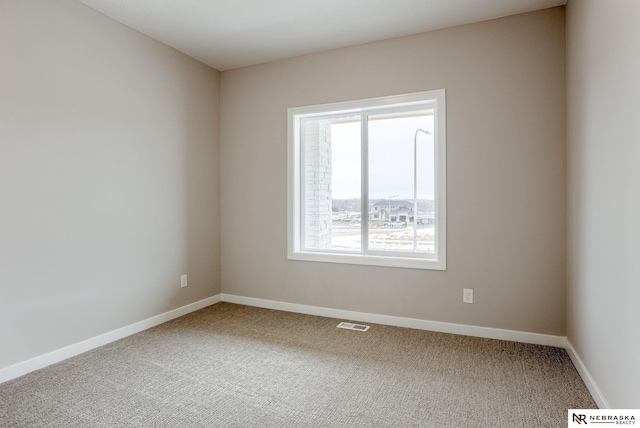 empty room featuring carpet flooring, visible vents, and baseboards