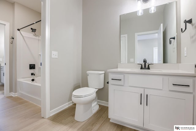 full bath featuring baseboards, toilet, wood finished floors, bathtub / shower combination, and vanity