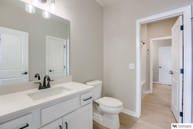 full bathroom featuring toilet, wood finished floors, vanity, baseboards, and shower / tub combo with curtain