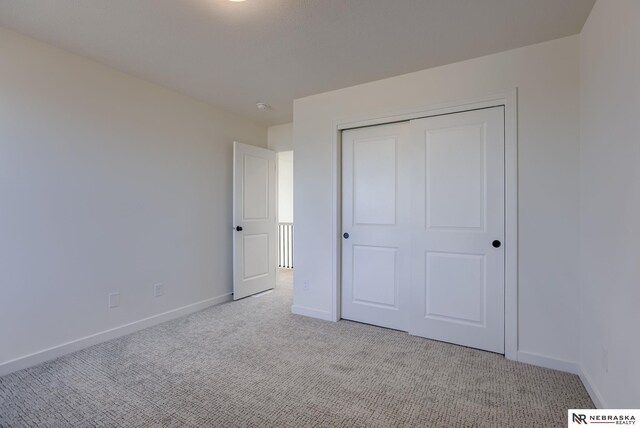 unfurnished bedroom with a closet and light carpet