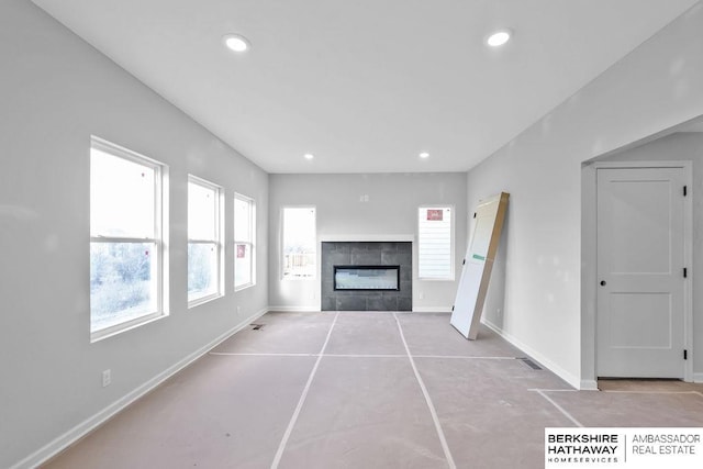 unfurnished living room featuring a tile fireplace