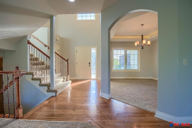 foyer entrance featuring carpet flooring and a chandelier