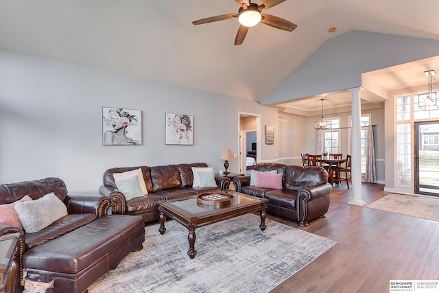 living room featuring ornate columns, hardwood / wood-style floors, ceiling fan with notable chandelier, and lofted ceiling