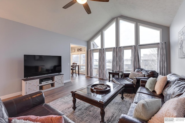 living room featuring ceiling fan, light hardwood / wood-style flooring, and vaulted ceiling