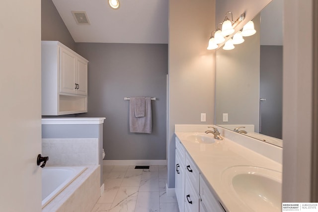 bathroom with vanity and tiled tub