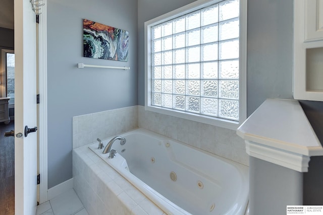 bathroom featuring tile patterned flooring and a relaxing tiled tub