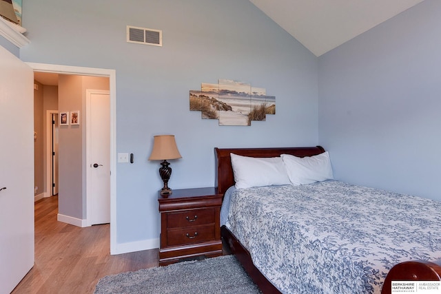 bedroom featuring light hardwood / wood-style floors and vaulted ceiling