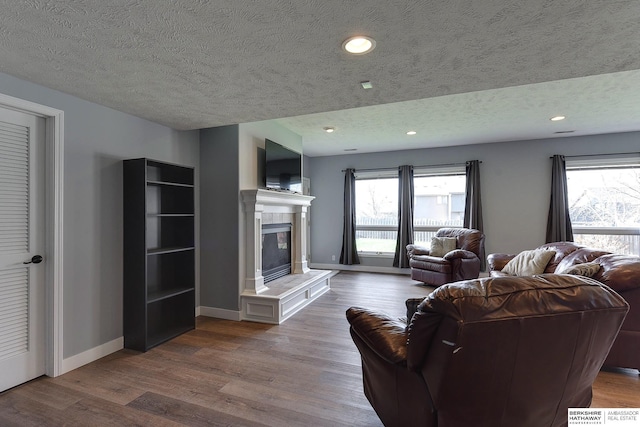 living room featuring a fireplace, light hardwood / wood-style floors, and a textured ceiling