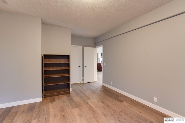 interior space with a textured ceiling and light wood-type flooring