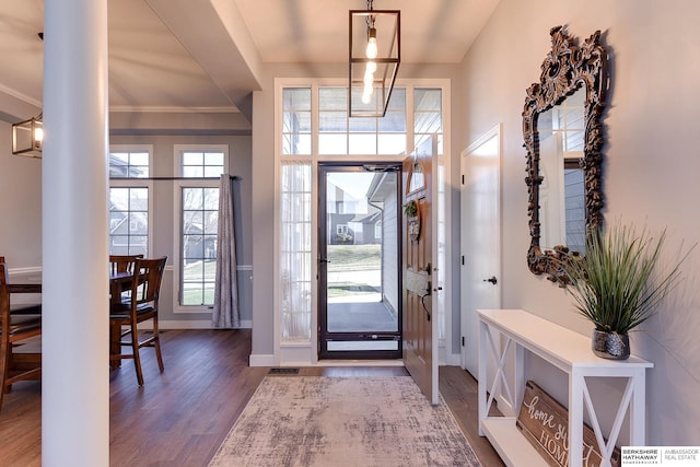 foyer entrance featuring crown molding and dark hardwood / wood-style floors