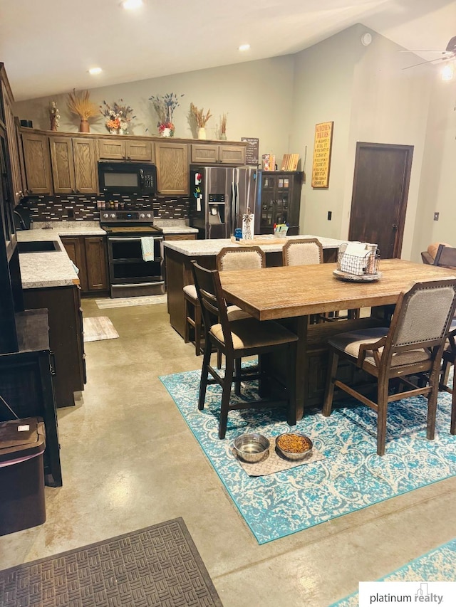 dining room featuring sink, vaulted ceiling, and ceiling fan