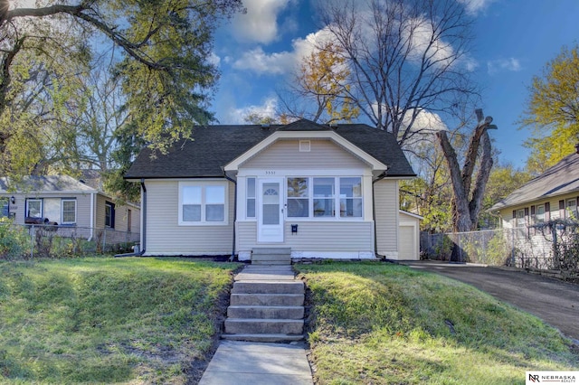 bungalow-style house with a garage and a front yard