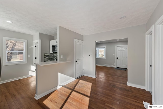 interior space featuring a textured ceiling, dark hardwood / wood-style floors, and a wealth of natural light