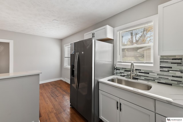 kitchen with sink, dark hardwood / wood-style floors, stainless steel refrigerator with ice dispenser, decorative backsplash, and white cabinets