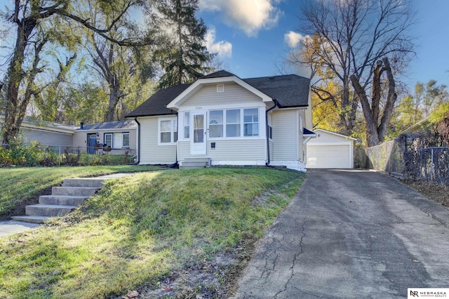 view of front of property featuring an outbuilding, a front lawn, and a garage