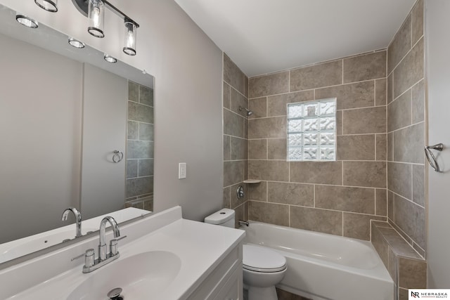 full bathroom featuring toilet, vanity, and tiled shower / bath