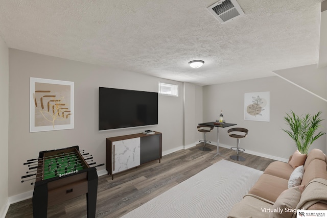 living room with a textured ceiling and dark hardwood / wood-style floors