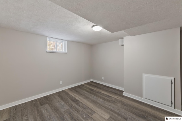 basement with dark hardwood / wood-style flooring and a textured ceiling