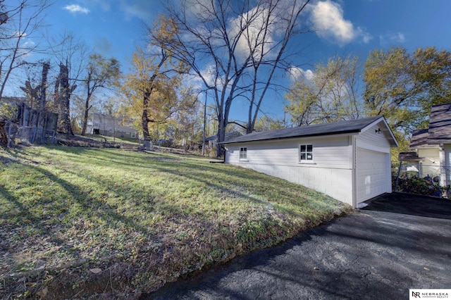 view of side of property with a yard, an outdoor structure, and a garage