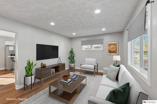 living room featuring a textured ceiling and light hardwood / wood-style floors