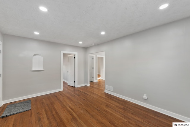 unfurnished room with hardwood / wood-style floors and a textured ceiling