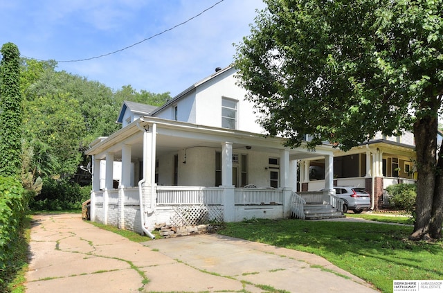 view of front of property with covered porch and a front lawn