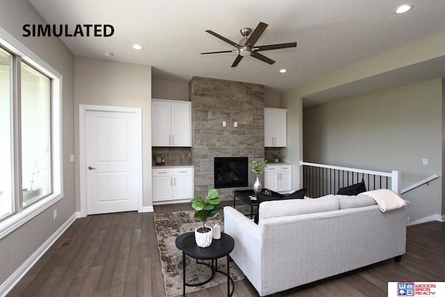 living room featuring dark hardwood / wood-style floors, a stone fireplace, and ceiling fan